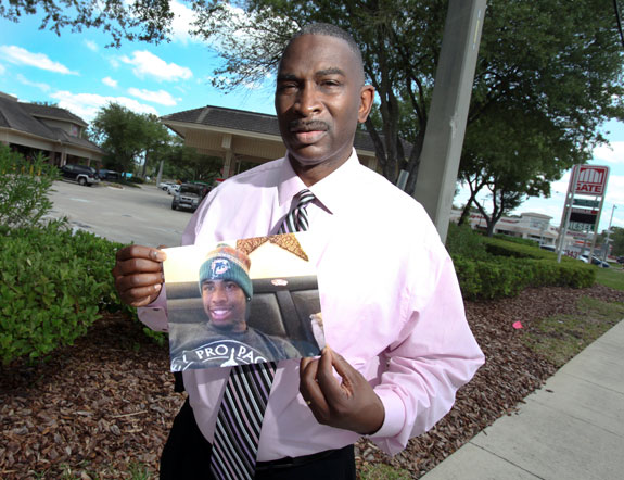 Ron Davis holds the last-known picture of his 17-year-old son Jordan Davis, who was shot and killed at this Jacksonville gas station Nov. 23, 2012. (Photo by Walter Coker.)