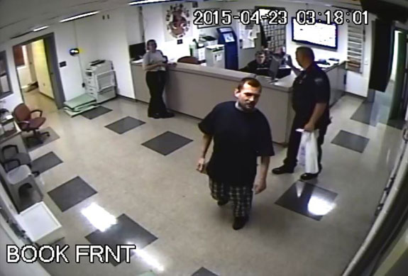 Adam Horine is escorted from jail by Officer Ron Dickow in this image from jail surveillance video.