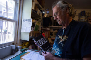 Richard Jergenson holds one of his notebooks detailing his plans to open a cannabis culture museum. Jergensen, a self-described archivist, has collected cannabis-related media and magazines for the past 45 years. (Sean Logan/News21)